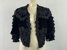 "Vintage or antique Gothic Bolero jacket. Made of black velvet and black silk. Victorian Gothic design. Incredible filigree like rolled lacework, I don't know what you call the technique. Fine folded and layered fluffy sleeves. High cut Bolero style back. Buttonless front. No label. About a size medium.  Measurements are:   40\" around the bust    15\" shoulder seam to shoulder seam  16\" shoulder seam to cuff   23\" overall length front  12\" overall length back In very good condition" Black Velvet Costume Outerwear, Vintage Velvet Outerwear For Costume, Vintage Velvet Costume Outerwear, Vintage Black Velvet Outerwear, Black Vintage Velvet Outerwear, Black Velvet Vintage Outerwear, Gothic Bolero, Fluffy Sleeves, Victorian Jacket