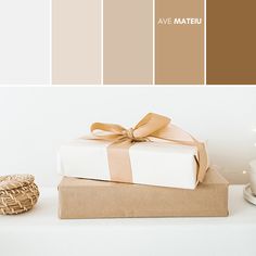 a present wrapped in brown and white paper on top of a box with a bow