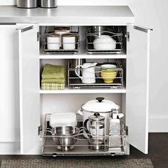 an open cabinet with pots and pans on the bottom shelf in front of it