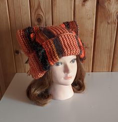 a mannequin head wearing a knitted hat on top of a white table