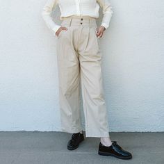 The Kate Pants Are A Wear-Anywhere Style. The Pleats Add A Tailored Touch While Maintaining Comfort And The Double Buttons Add Interest To The Waistline. Double Button, Elastic Back, Pleats, Functional Pockets, Belt Loops Pair With Lena Shirt And Loafers For Work Or Wear It Casually With A Fitted Tank, Baseball Cap, And Chunky Sneakers. Measurements: S/ Waist: 12-13.5" Stretched, Hip: 20", Rise: 13", Length: 26" M/ Waist: 13-15" Stretched, Hip: 20", Rise: 13", Length: 26" L/ Waist: 14-16" Stretc Ankle-length Business Casual Pants With Buttons, Business Casual Straight Pants With Buttons, Straight Pants With Buttons For Business Casual, High-waisted Chinos With Button Closure For Work, Chic Relaxed Fit Pants With Buttons, Classic Bottoms With Buttons For Fall, Classic High Waist Spring Chinos, Beige Work Pants With Belt Loops, Business Casual High-waisted Pants With Buttons