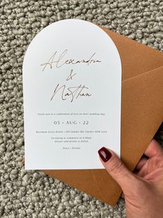 a hand holding an envelope with a wedding card in it