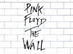 the words pink floyd and the wall written in black ink on a white brick wall