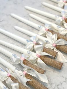 several white candles with bows on them