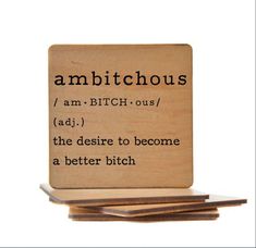 a wooden coaster with the words ambitcuss on it and an ad in black ink