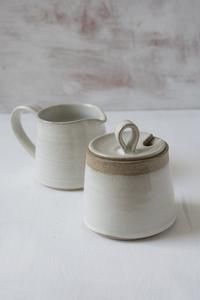 two white mugs sitting next to each other on a table