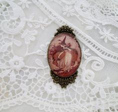 "With wonderful color and clarity, encased in an antiqued Victorian bronze toned setting our fine art cameo brooch measures 2.5 inches in length. The Victorian vintage artwork is set under a high quality glass dome.  Every item in our shop is handmade and created with loving care. For your timeless style!  Please note: The glare on the cameo occurs from the photo and is not a blemish on the piece. Our cameos are resistant but not waterproof and should not be submerged in water or worn when swimming or bathing. Each time you happen to me all over again! ~The Age of Innocence Your jewelry arrives in a white jewelry box tucked inside a lovely organza bag, ready for gift giving. If your order is being sent directly to a gift recipient, we are delighted to take part in your thoughtfulness and a Vintage Brooch With Antique Finish, Vintage Halloween Brooches For Gift, Vintage Halloween Brooches, Victorian Brooch, The Age Of Innocence, Samhain Halloween, White Jewelry Box, Cameo Brooch, Free Earrings