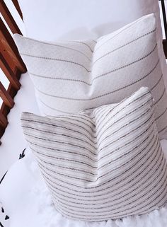 two white pillows sitting on top of a bed