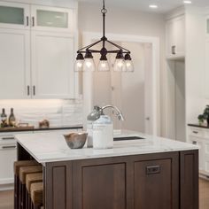 a kitchen island with lights hanging over it