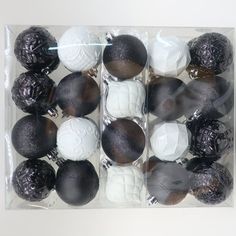 black and white ornaments in a clear box