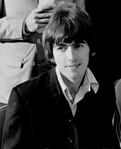 a black and white photo of a young man with his hair styled by the beatles