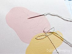 scissors and thread are on top of an art piece