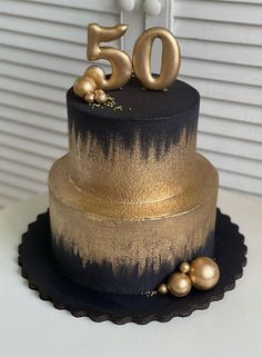 a black and gold cake with the number 50 on top