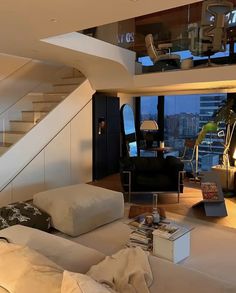 a living room filled with furniture next to a stair case