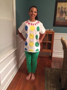 a woman standing in a living room with her hands on her hips and smiling at the camera