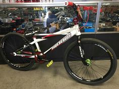 a white and red mountain bike parked in front of a store display with other items