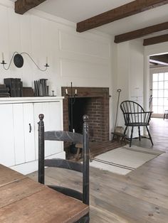 a living room filled with furniture and a fire place next to a wooden dining table