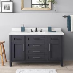 a bathroom vanity with two sinks and a large mirror over the top that hangs above it