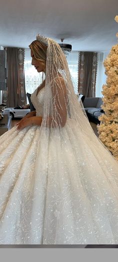 a woman in a wedding dress standing next to a christmas tree