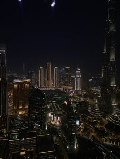 an aerial view of the city at night with lights and skyscrapers in the background