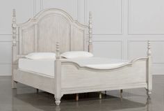 a white bed with two pillows on top of it's headboard and foot board