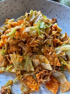 a white plate topped with cabbage and meat