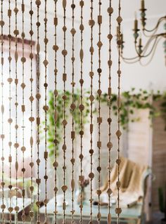 a room with a chandelier, table and curtains in it's windows