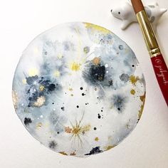 a painting with paint splattered on it next to a brush