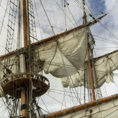 an old sailing ship with white sails and masts