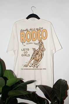 Get all of the southwestern vibes in this oversized This is My First Rodeo inspired tshirt!- Features the phrase "Actually, this is my first rodeo across the top with a cowgirl and horse & the phrase"lets go girls" / "the Underground Rodeo 1993" underneath it all in a yellow and brown ink- Screen print transfer that is heat pressed onto each tshirt- Tshirt is a super soft vintage wash that gets softer after each wash- Oversized fit- Sizing translation: XS/S = L , S/M = XL , L/XL = 2XL , 2XL/3XL Cowgirl Outfits With Tshirt, Cowgirl Tshirt Designs, Country T Shirts, Rodeo Tshirt, Cowgirl Tshirt, Lets Go Girls, Rodeo Girls, My First Rodeo, Rodeo Cowgirl