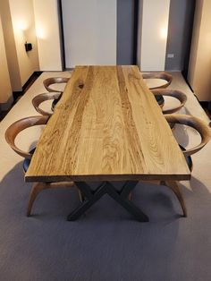 a wooden table sitting in the middle of a room with chairs around it and lights on either side