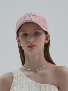 a woman wearing a pink hat and white top