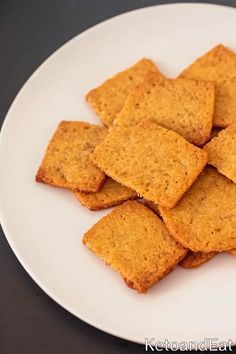 a white plate topped with crackers on top of a table