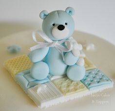 a blue teddy bear sitting on top of a cake