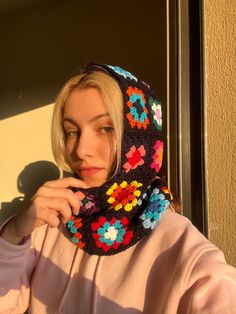 a woman wearing a crocheted flowered cowgirl neck scarf in front of a window