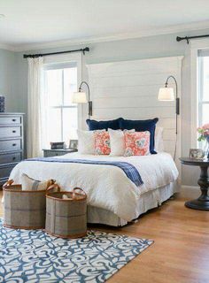 a bedroom with blue and white bedding, two lamps on either side of the bed