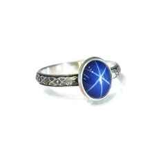 "Lab Created Blue Star Sapphire Ring Fascinating Brilliance! This stone is reminiscent of the vintage “Lindy” synthetic Star Sapphire of the 50s thru 70s. The star effect, known as an “asterism”, is more defined in a lab-grown Sapphire. They are identical in chemical composition, brilliance, and physical appearance as their natural counterpart, however they have fewer flaws, are not mined from the ground, and are much less expensive. They are an extremely durable stone with a Mohs scale hardness Star Effect, Blue Star Sapphire Ring, Salish Sea, Star Sapphire Ring, Blue Star Sapphire, Physical Appearance, Mohs Scale, Flower Vintage, Star Sapphire