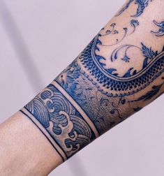 a man's arm with blue and white tattoos on it, showing the intricate design