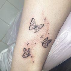 three butterflies flying in the air with stars on their wings, and one is black