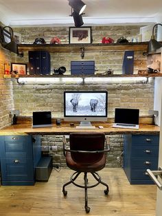 a computer desk with two monitors on top of it and shelves in the back ground