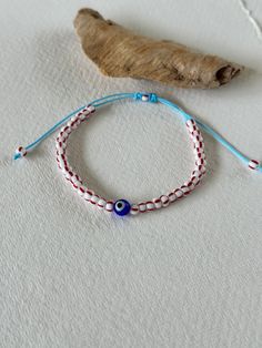 - Dive into the nautical charm of our latest collection with this red-striped Czech glass bead bracelet. Designed with summer in mind, the bracelet features a sky-blue adjustable cord that ensures a perfect fit for any wrist size. At the center, a glass evil eye bead adds a pop of culture and protection, symbolizing good fortune and warding off negative vibes. - The red stripes on the beads evoke a classic nautical aesthetic, reminiscent of sunny days by the seaside and sails on the horizon. It' Czech Glass Bead Bracelet, Nautical Aesthetic, Summer Layering, Layering Jewelry, Glass Bead Bracelet, Glass Beaded Bracelets, Layered Jewelry, Evil Eye Charm, Summer Accessories