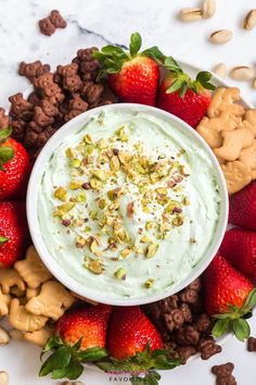 a bowl filled with whipped cream surrounded by nuts and strawberries on a white plate