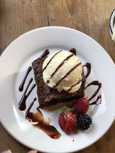 a piece of chocolate cake with ice cream and strawberries