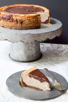 a piece of cheesecake on a plate with a fork next to it and another slice missing