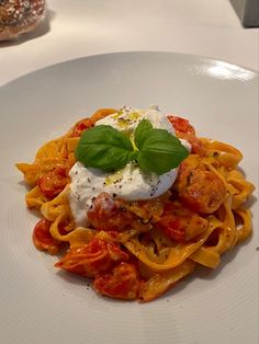 a white plate topped with pasta covered in tomato sauce and cheese on top of it