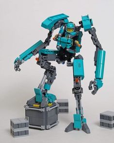 a lego robot standing next to some blocks