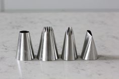 four metal cones sitting on top of a white counter