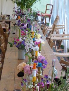 a long table with flowers and candles on it