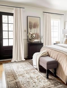 a large bed sitting in a bedroom on top of a wooden floor next to a window