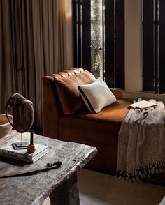 a brown couch sitting next to a wooden table